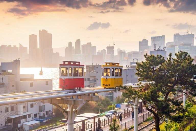 Haeundae Blueline Park sky capsules on the elevated coastal track at sunset.
