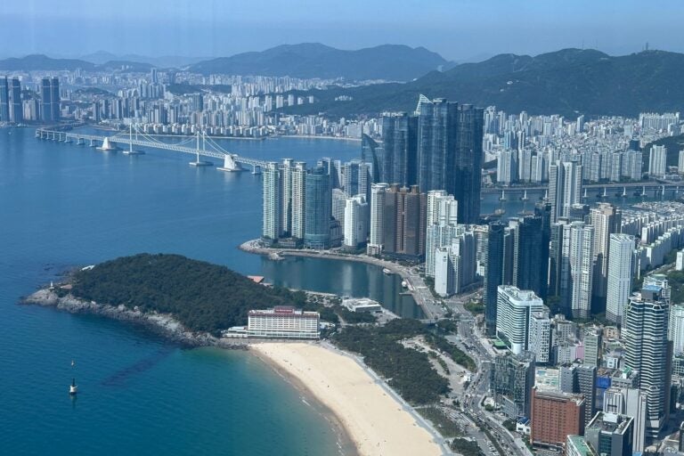 Aerial view of Haeundae Beach and Gwangan Bridge, lined with Busan's high-rise waterfront towers