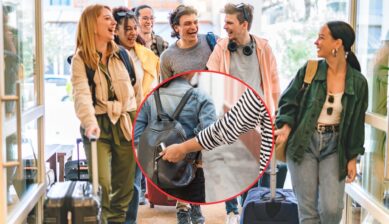Group of smiling travelers walking with luggage, with a circular inset showing a hand pulling a smartphone from an unaware traveler's backpack.