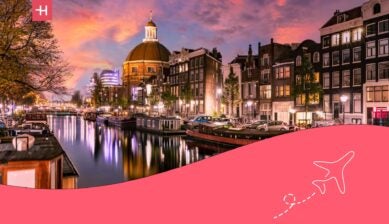 the canals in amsterdam lit up in the evening against the backdrop of a beautiful evening sky - cost of living in the netherlands