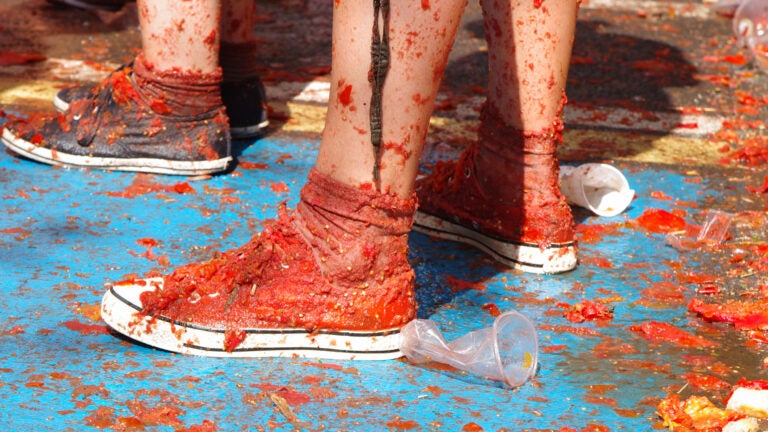 Sneakers splattered and soaked with red tomato pulp during the La Tomatina festival