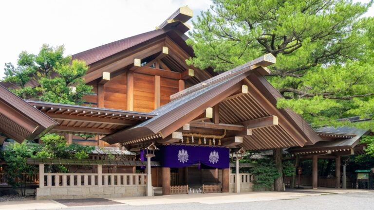 Forested precinct of Atsuta Shrine with a traditional wooden torii gate and stone pathway in central Nagoya