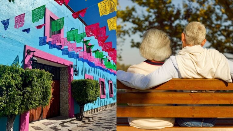 A retired couple beside a colorful street decorated with papel picado in Oaxaca, Mexico.