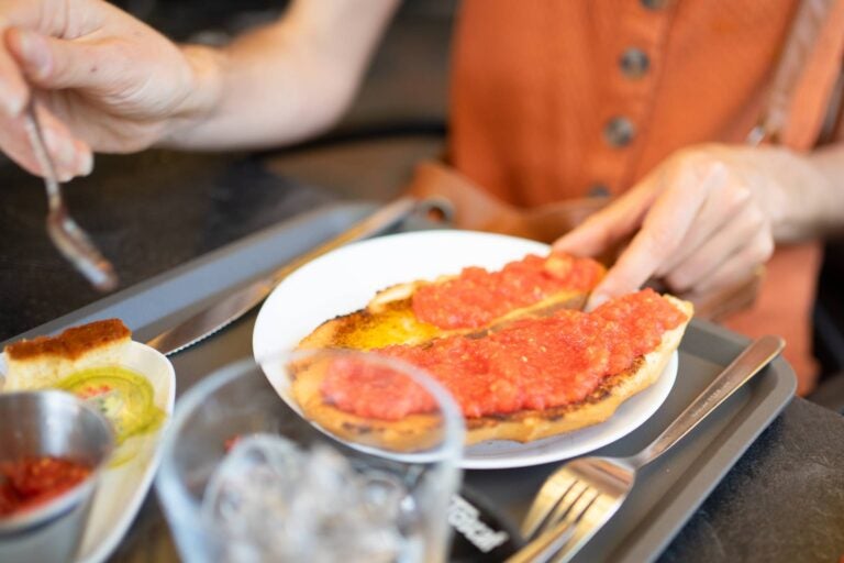 people adding tomato paste to a pa amb tomàquet