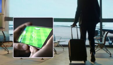 A traveler in silhouette pulling a suitcase through an airport terminal toward the window, with an inset close-up of hands holding a smartphone streaming a live soccer match.