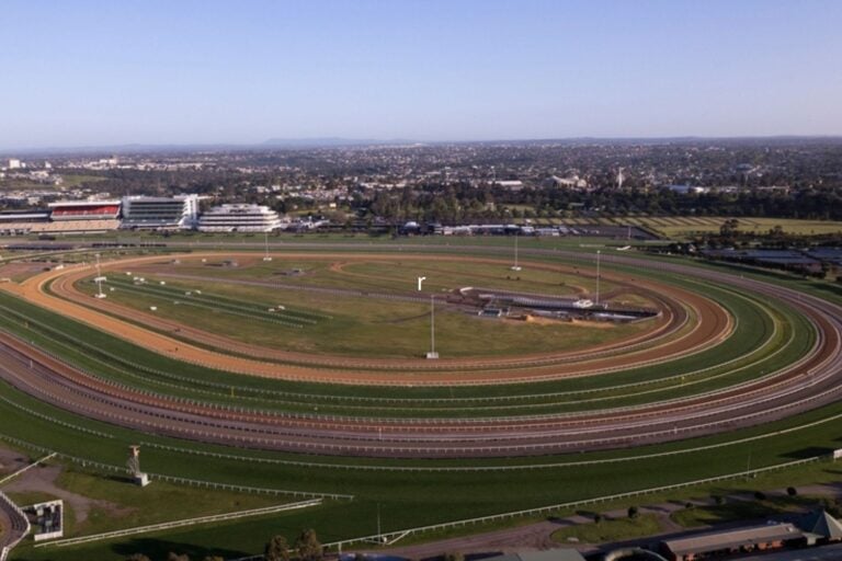 Aerial view of Flemington Racecourse in Melbourne, showing the oval track and grandstand.