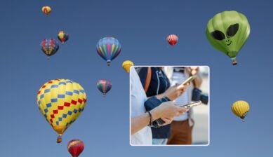 Hot air balloons filling the sky above Albuquerque, with an inset of travelers checking their phones in a crowd