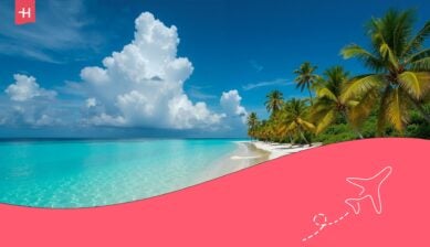 Tropical beach in Mauritius with clear turquoise water, white sand, and palm trees, illustrating the cost of living in Mauritius.