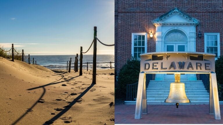 Delaware beach dunes beside a replica of the Liberty Bell.