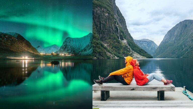 Northern lights over snowy mountains and a fjord in Norway beside travelers resting on a dock