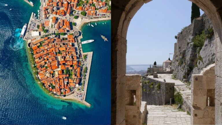 Aerial view of a red-roofed Croatian coastal town beside a stone fortress overlooking the sea