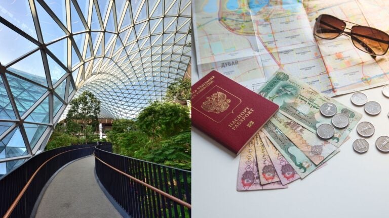 Modern indoor walkway alongside a passport, Qatari riyal banknotes, coins, map, and sunglasses.