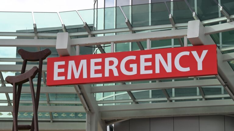 A red illuminated emergency sign marking the ER entrance at a hospital