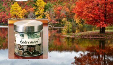 A glass jar labeled "Retirement" filled with coins and cash, set against Virginia's autumn foliage reflected in a calm lake