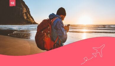 man on the beach, browsing his phone - Holafly Ultra Plan review
