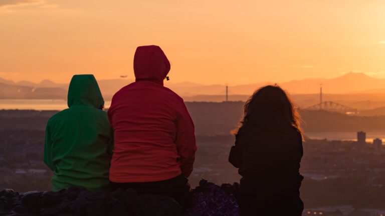 People on the summit of Arthur’s Seat watching the sunset over the Firth of Forth