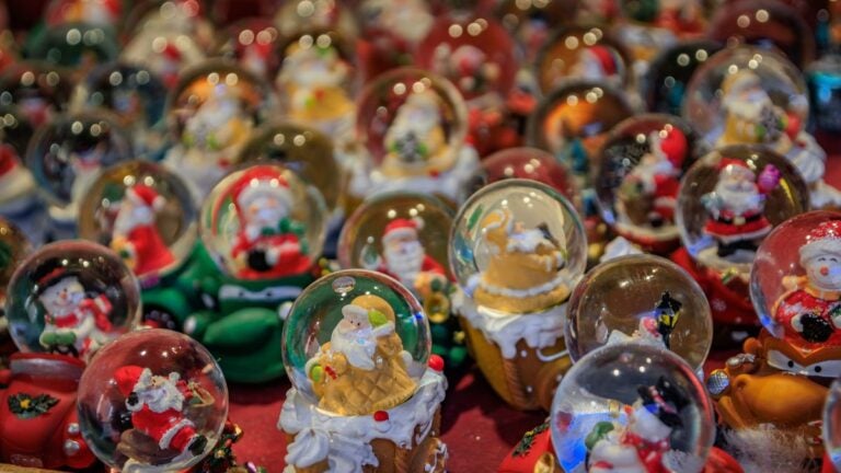 Glass snow globe Christmas ornaments on sale at a Colmar Christmas market chalet