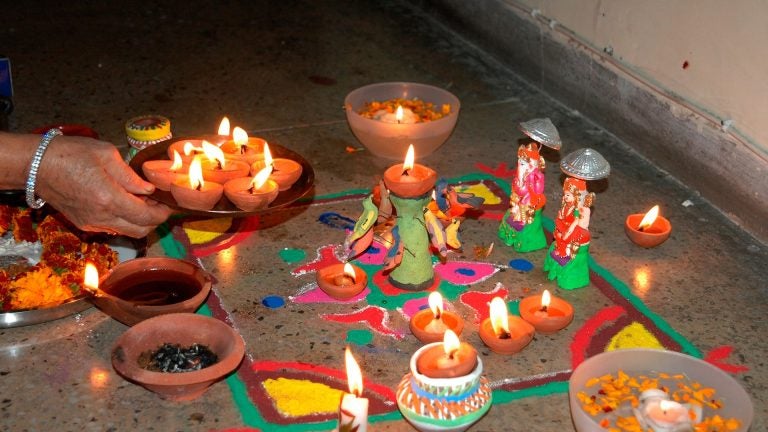 Small lit oil lamps glowing in the dark, their flames casting a warm orange light.