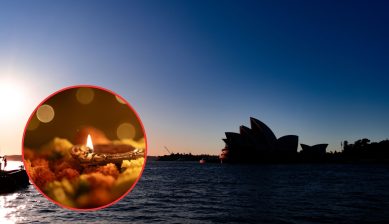 The Sydney Opera House silhouetted against a deep blue sky at sunset over Sydney Harbour, with a red-bordered circular inset showing a lit brass diya lamp resting on orange marigold flowers.