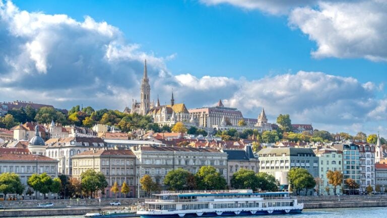 Panorama Budapesztu nad Dunajem z rejsem rzecznym i Wzgórzem Zamkowym w tle.