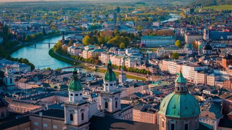 Widok z góry na Salzburg z kopułami kościołów i rzeką Salzach.
