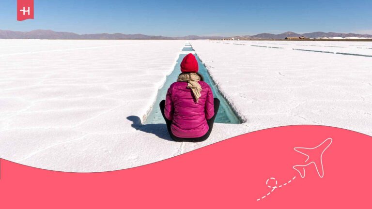 Eine junge Frau sitzt allein auf dem Eis in den Salaren in Argentinien.