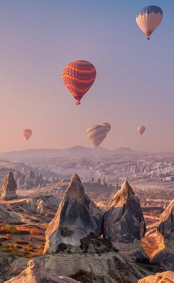 Heißluftballons am Himmel bei Sonnenuntergang in Kappadokien, Türkei