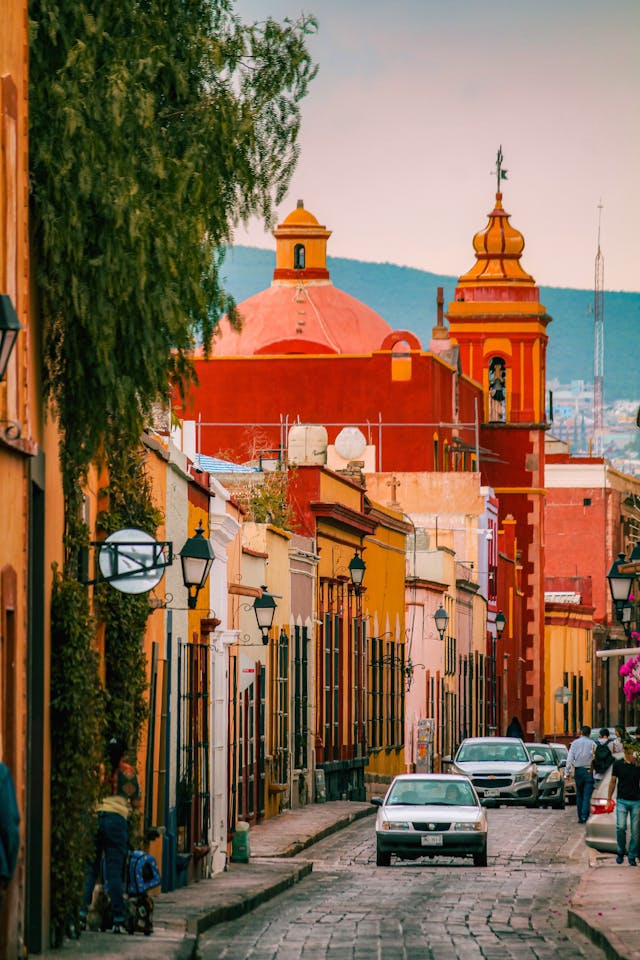 
Eine bunte Straße in Guanajuato mit der Kirche San Miguel de Allande im Hintergrund, Mexiko.