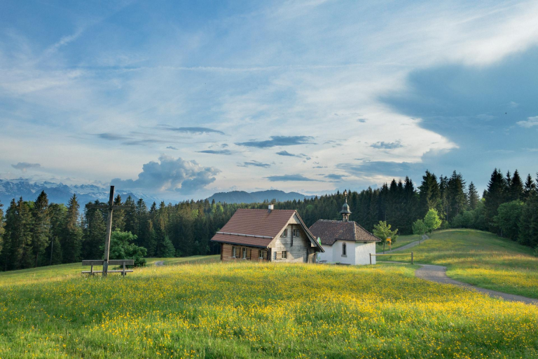 Weißes und braunes Haus auf einer grünen Wiese unter blauem Himmel in Oberägeri, Schweiz