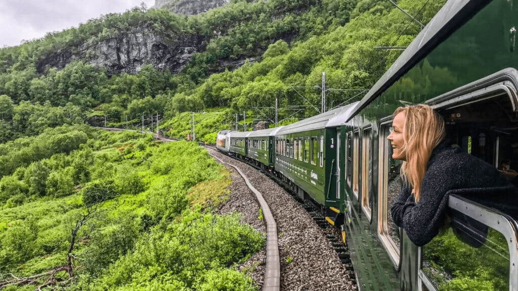 Eine Frau, die durch ein Zugfenster in Europa die Landschaft betrachtet.