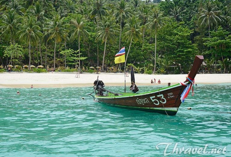 Ein Wassertaxi im türkisfarbenen Wasser des Freedom Beach in Thailand