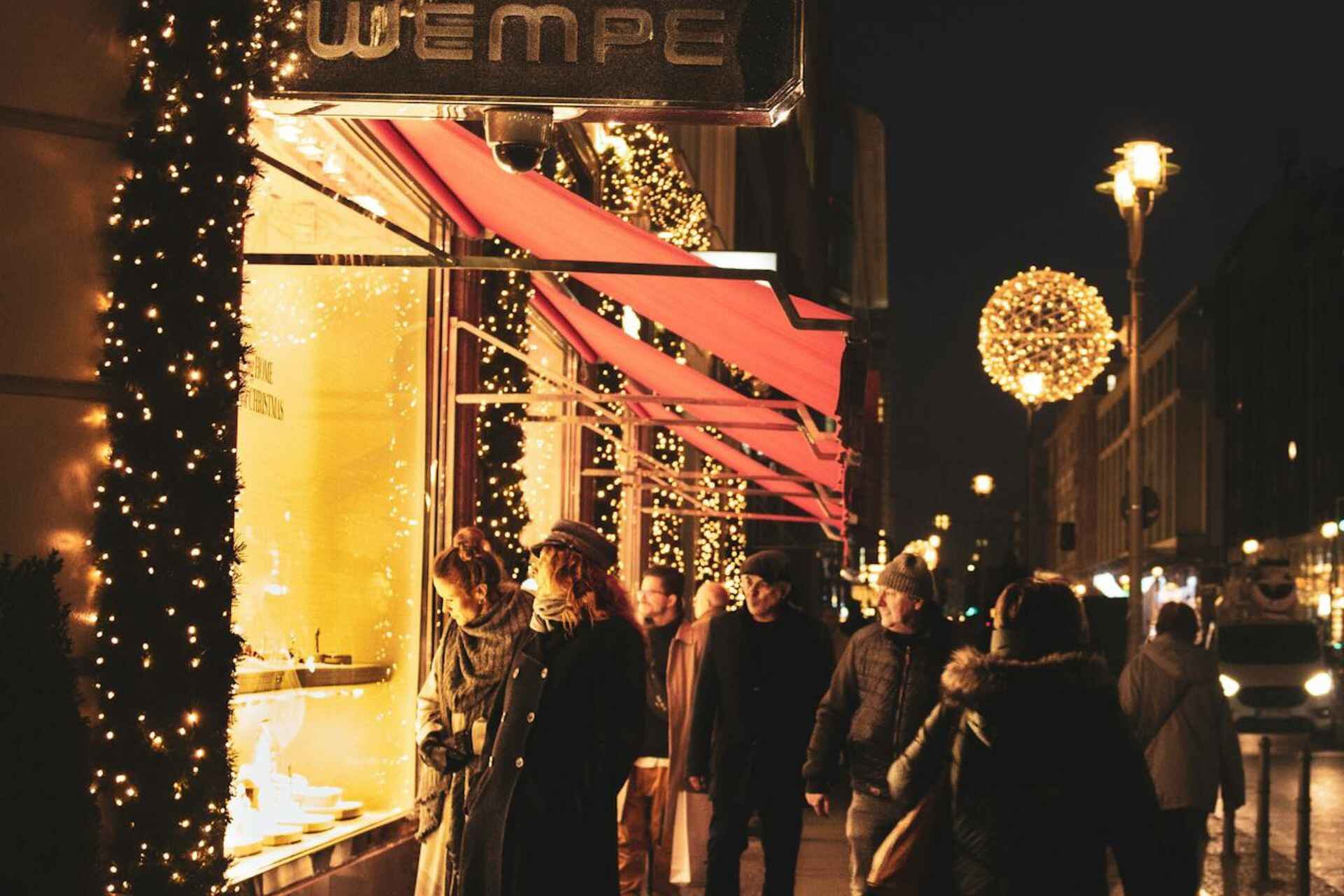 Weihnachtseinkäufe in einer beleuchteten Straße in Berlin, Deutschland