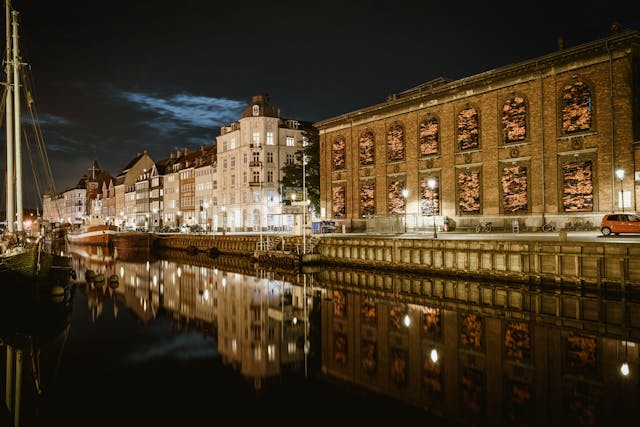 

Beleuchtete Gebäude Reflexion im Kanal bei Nacht in Kopenhagen, Dänemark
