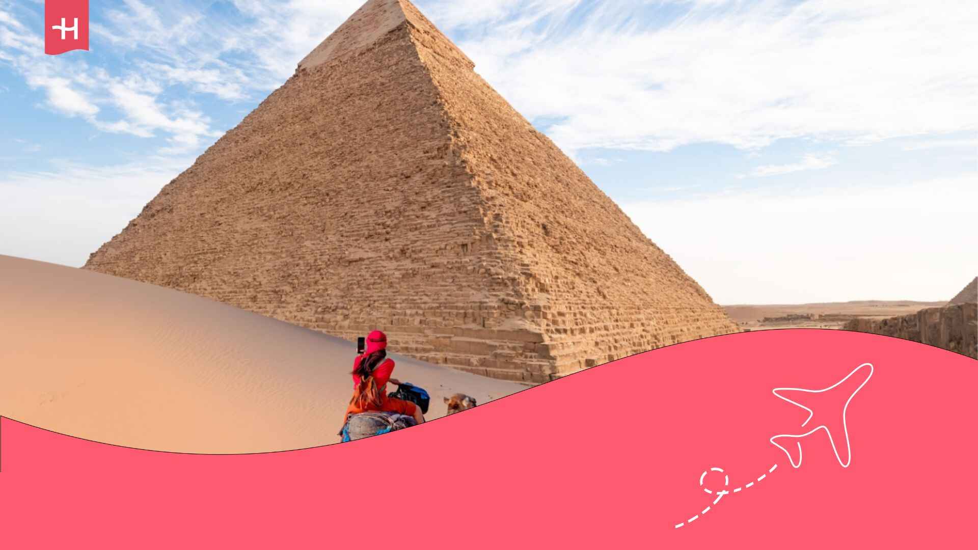 Eine Frau mit rotem Turban reitet auf einem Kamel über die dünnen Sanddünen vor der Pyramide von Gizeh, Kairo, Ägypten