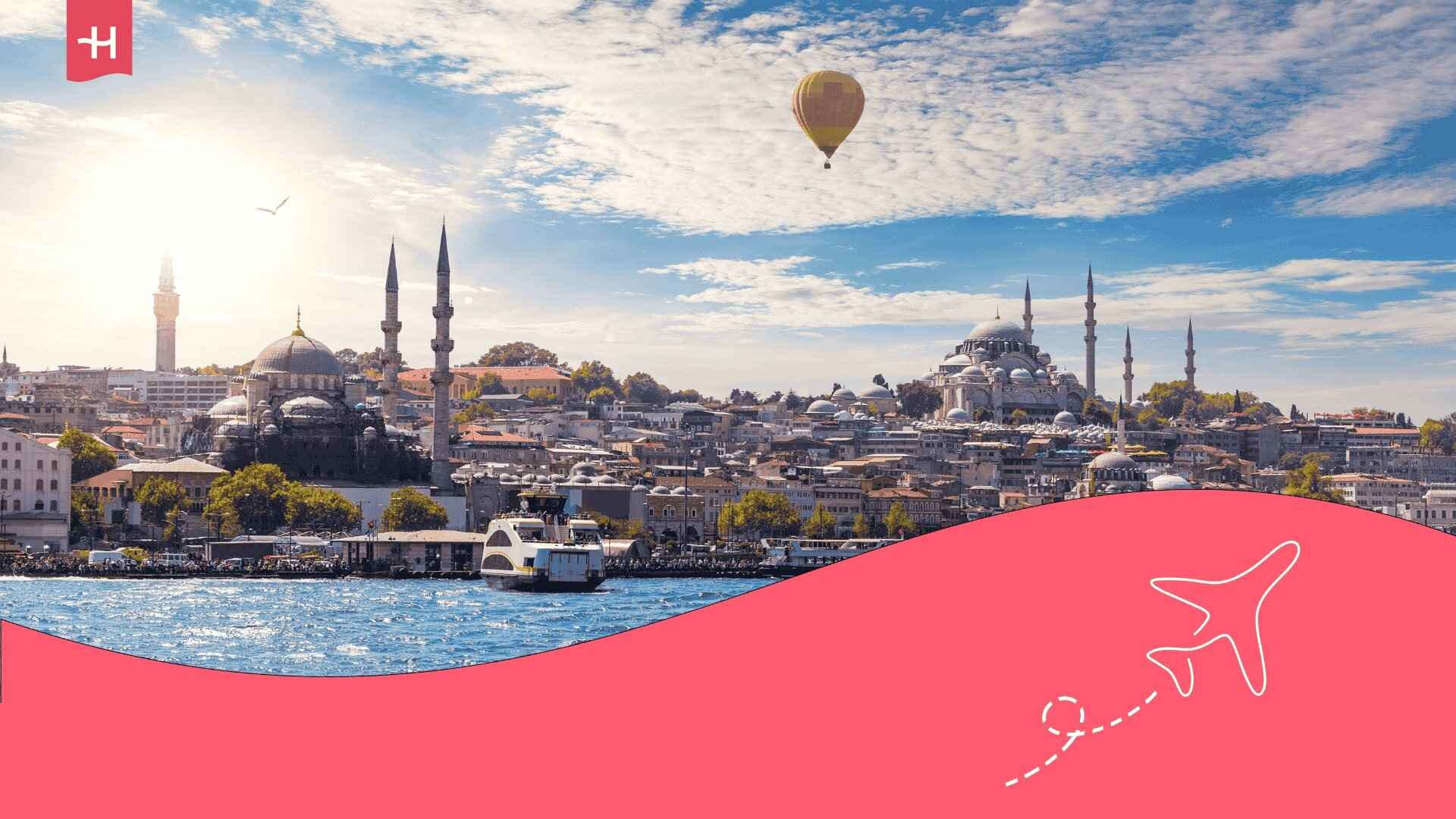 Blick vom Bosporus auf die Stadt Istanbul in der Türkei mit einem Heißluftballon, der über die Metropole schwebt.