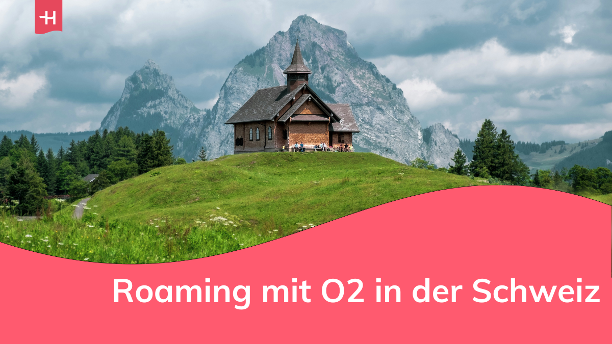Eine kleine traditionelle Schweizer Kirche mit den Bergen im Hintergrund.