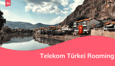 Blick auf eine kleine türkische Stadt am Fluss, an einem der Gebäude hängt eine Flagge
