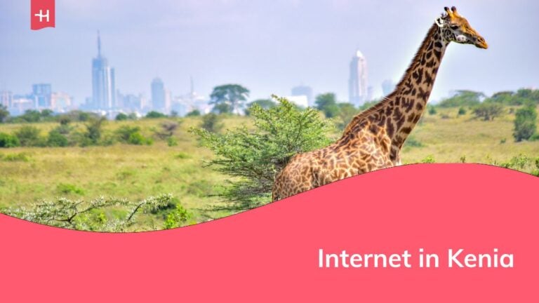 Eine Giraffe vor einer Stadt im Hintergrund in Kenia.