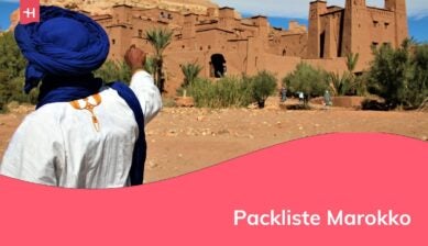 Ein Beduine mit Touristen an einem Touristenort in der marokkanischen Wüste.