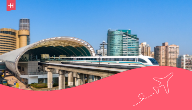 Ein Zug in Shanghai und im Hintergrund die Skyline der Stadt.