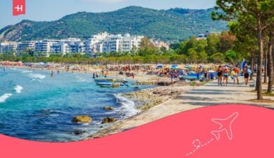 Reiseziel im August mit belebter Strandpromenade, Meerblick und sommerlicher Küstenlandschaft