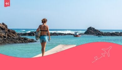 Eine Frau, die auf einem Pier auf einer spanischen Insel spazieren geht.