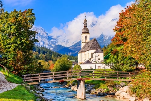 Malerische Ansicht einer Kirche in Berchtesgaden mit Bergen im Hintergrund, eines der besten Reiseziele im Januar