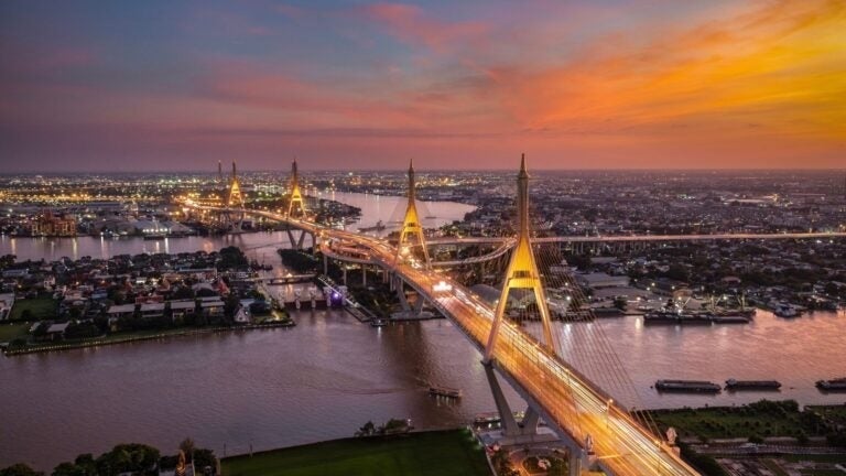 Luftaufnahme der Bhumibol-Brücke bei Nacht.