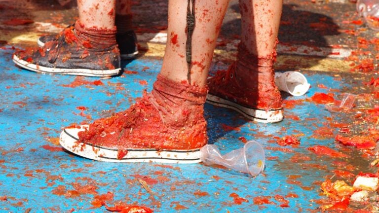 La Tomatina in Spanien im August mit tomatenverschmierten Schuhen und Festivalstimmung