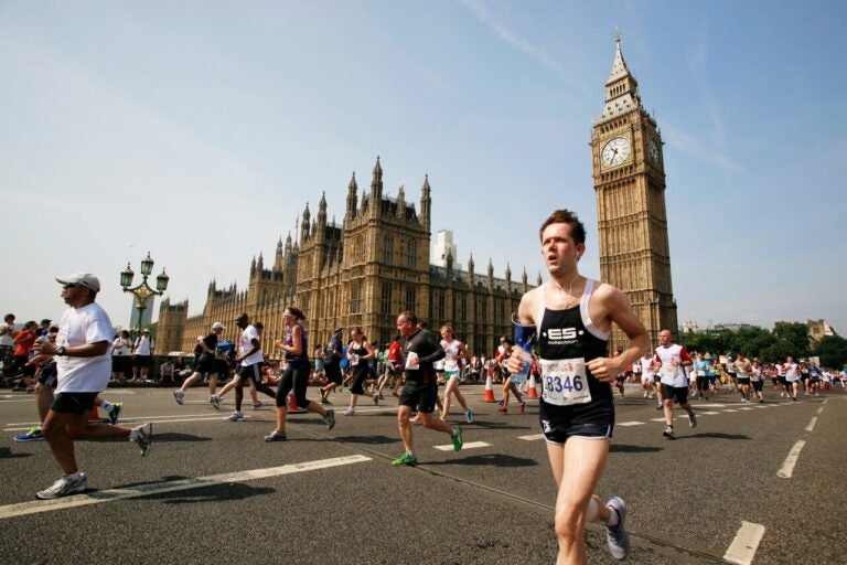 Teilnehmer beim London Marathon laufen an Big Ben und dem Palace of Westminster vorbei