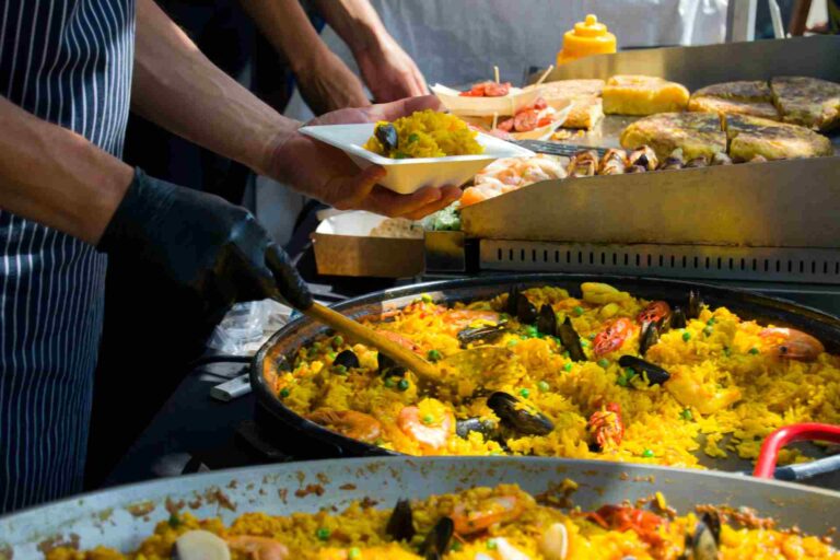 Zubereitung einer traditionellen Paella Valenciana auf einem Straßenfest während Las Fallas in Valencia