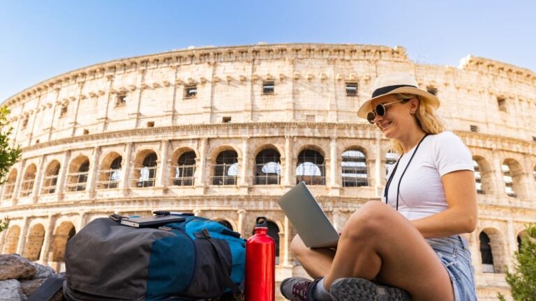 Rom im Oktober mit dem Kolosseum und Reisender beim Arbeiten im Freien