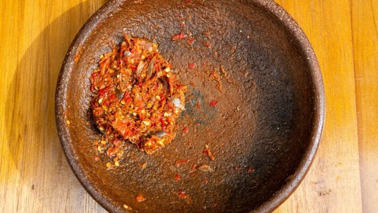 Traditionelle Sambal-Paste mit balinesischen Gewürzen in einer Steinmörserschale