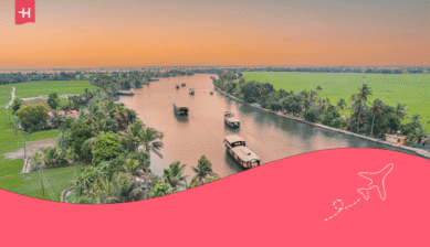 Hausboote auf den Backwaters in Kerala bei Sonnenuntergang als Beispiel für interessante Fakten über Indien